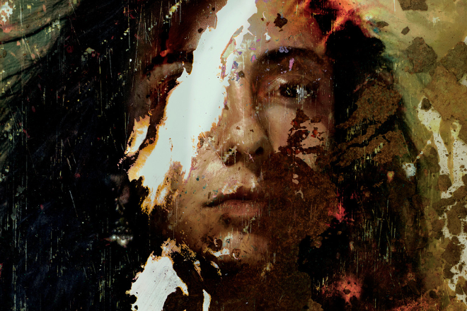 Portrait of a person’s face partly covered by irregular paint splatters and textures, creating an abstract, grunge look.