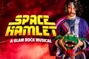 Poster for Space Hamlet — A Glam Rock Musical; a costumed man holds a green dragon puppet against a red smoky background.
